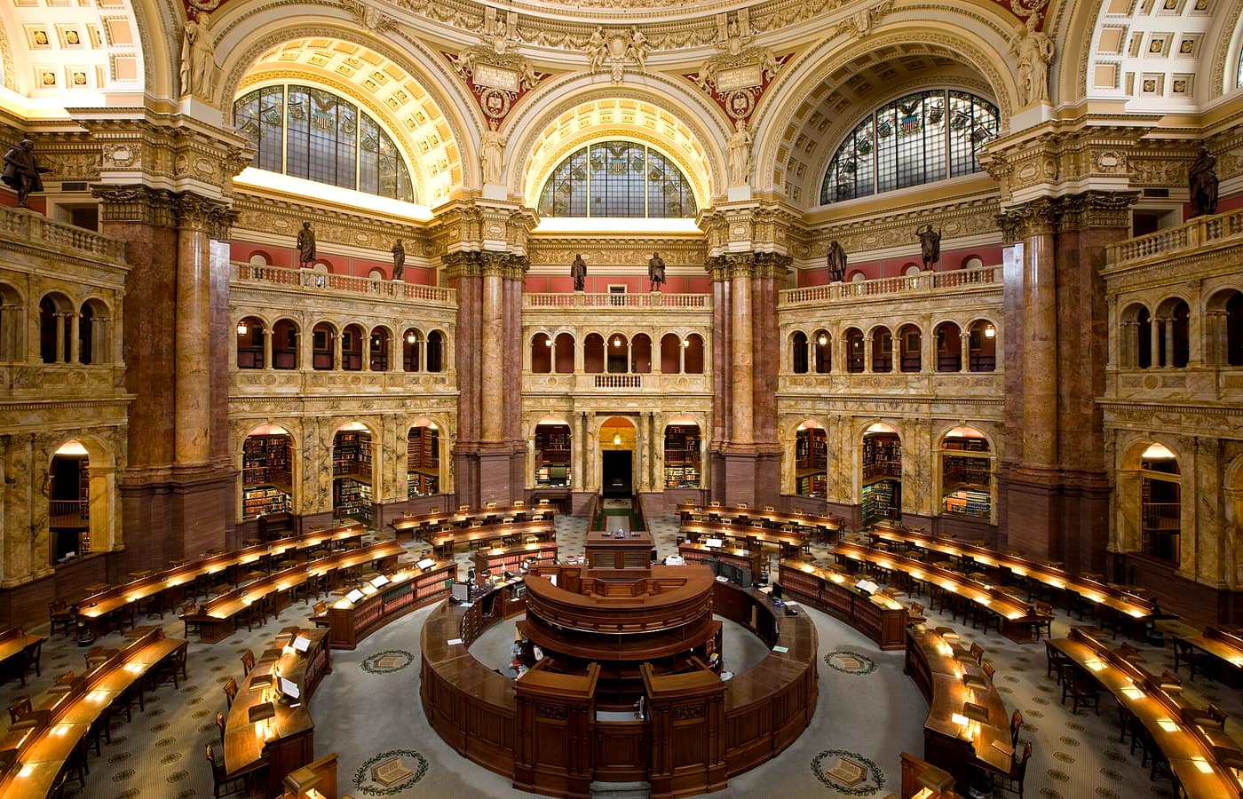 The ornate Main Reading Room of the Library of Congress, ringed with desks beneath a domed ceiling.