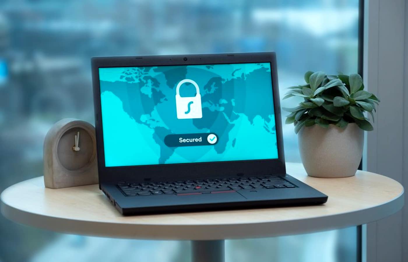 A laptop on a table showing a padlock and a Secured status on screen.