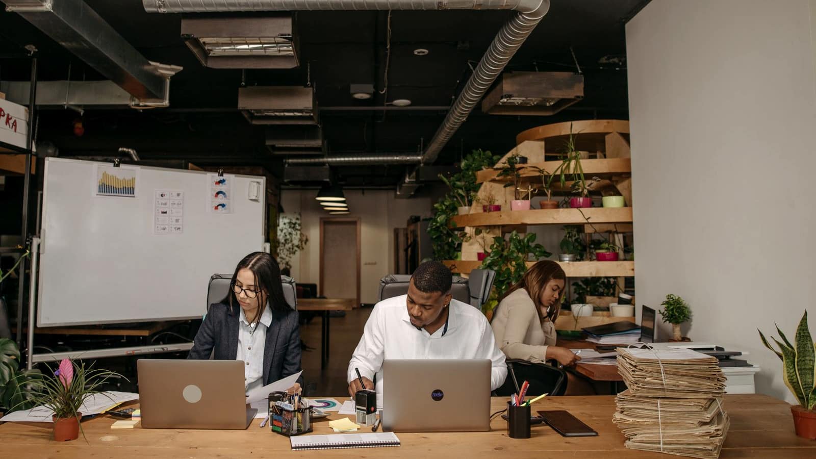 A small startup team working together at a table with laptops in a modern office